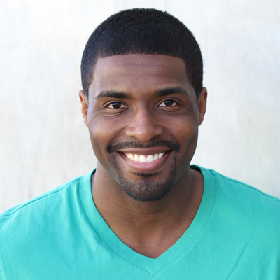 An elderly couple posing together with smiles on their faces, embracing each other in front of a scenic background.