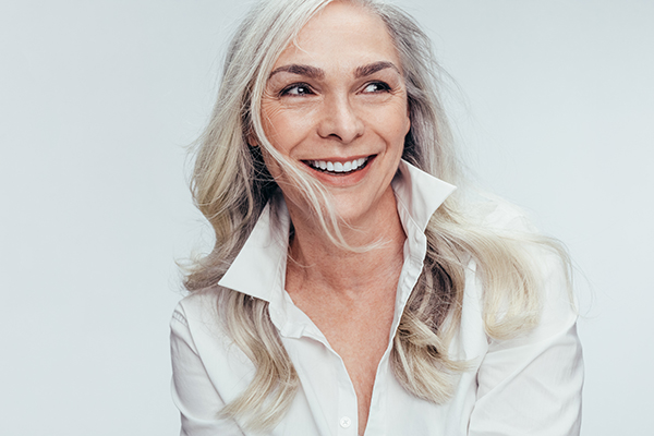 The image shows a woman with blonde hair smiling at the camera.